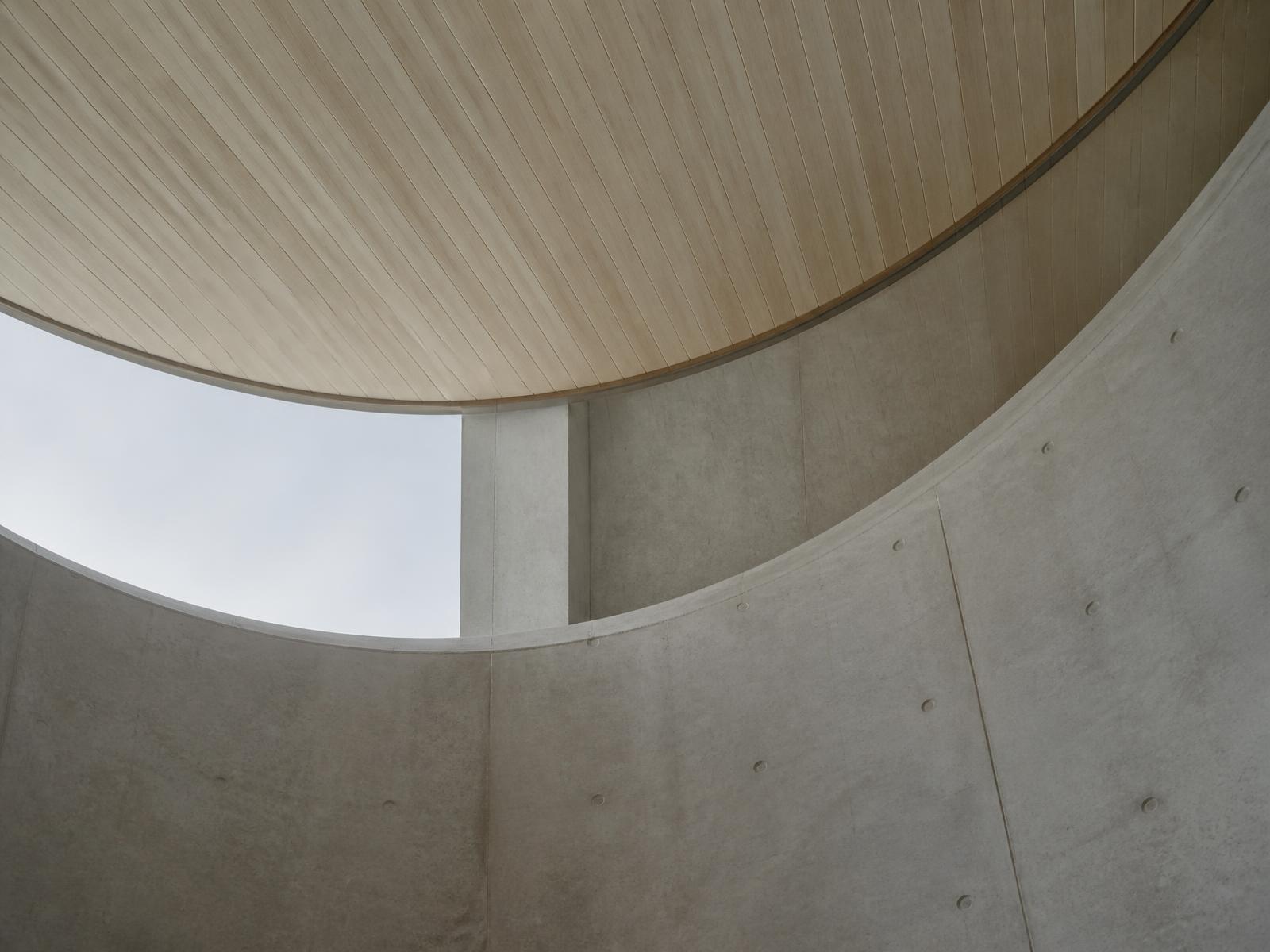 Curved concrete and timber architecture viewed from below